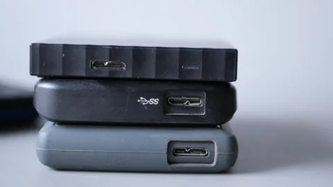 Stack of external hard drives with usb 3.0 micro b ports on white backgroun.. Stock Footage 332745703