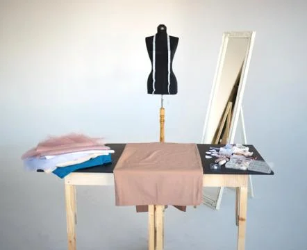 A stack of fabrics and sewing accessories on a tailor's table Fotos de archivo