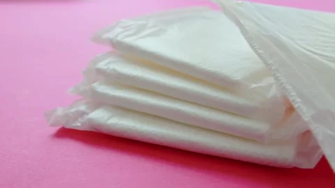 A stack of feminine sanitary pads on a pink background. The concept of hygiene Video stock 253470641
