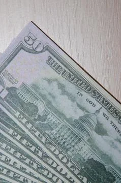 A stack of fifty 50 dollar bills fanned out on a wood Stock-Fotos