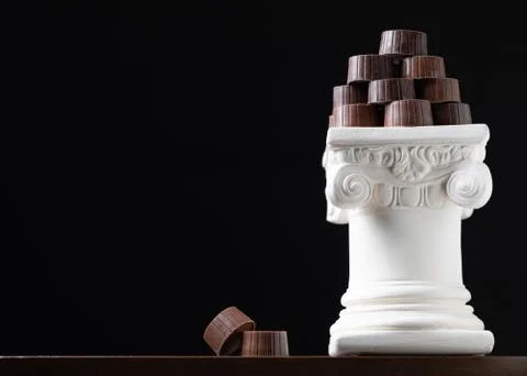 Stack of Fine Artisan Chocolates Stacked On White Pillar Column. Stock Photos