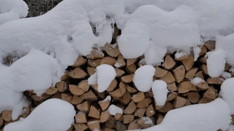 Stack of firewood covered with snow in winter. snow is falling Stock Footage 125181353