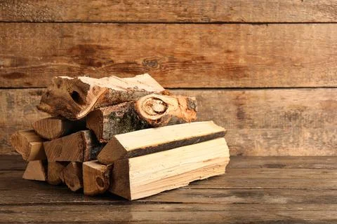 Stack of firewood logs on wooden background Stock Photos