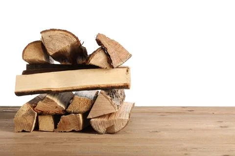 Stack of firewood logs on wooden table against white background Stock Photos