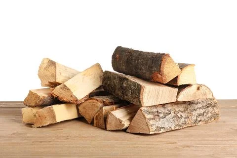 Stack of firewood logs on wooden table against white background Stock Photos
