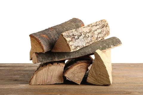 Stack of firewood logs on wooden table against white background Stock Photos