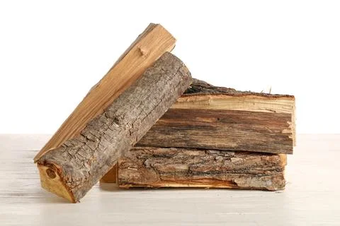 Stack of firewood logs on wooden table against white background Stock Photos