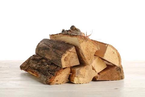 Stack of firewood logs on wooden table against white background Stock Photos