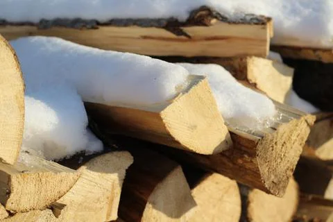 Stack of firewood snow covered in winter Stock Photos