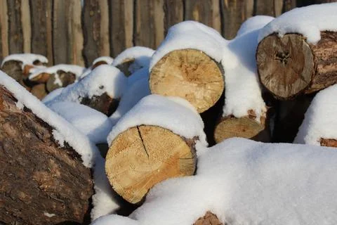 Stack of firewood snow covered in winter Stock Photos