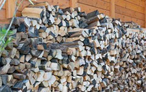 Stack of firewood stacked against the wall to heat the house in winter Stock Photos