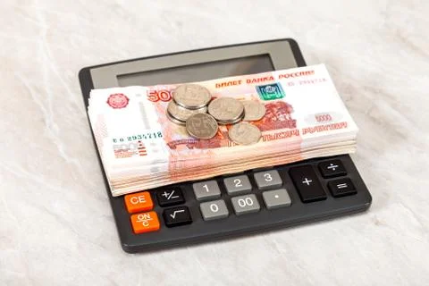 Stack of five thousandths banknotes of russian roubles, coins and calculator Stock Photos