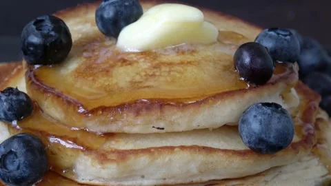 A stack of fluffy breakfast American pancakes with fresh blueberries. Vídeo Stock 336589320
