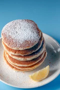 Stack of fluffy pancakes with powdered sugar and lemon slice Stock Photos