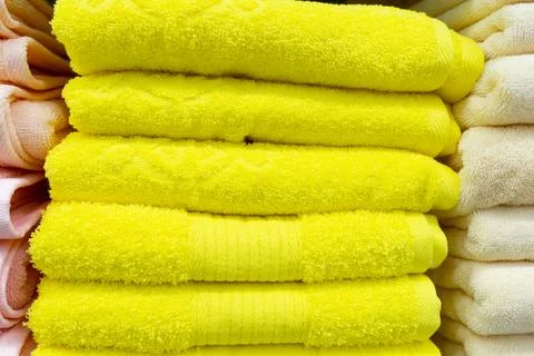 A stack of fluffy yellow towels in close-up Stock Photos