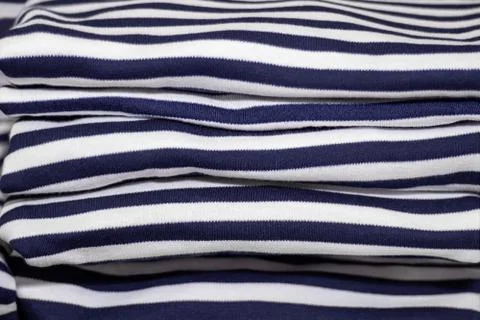 Stack of folded and ironed striped T-shirts close up Stock-Fotos