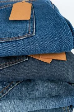 Stack of folded blue jeans on a white background Stock Photos