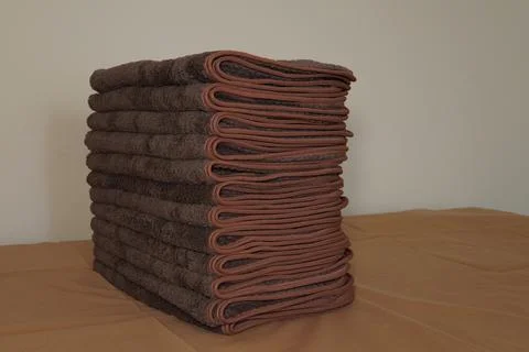 A stack of folded brown hand towels. 스톡 사진