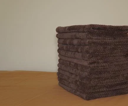A stack of folded brown hand towels. 스톡 사진