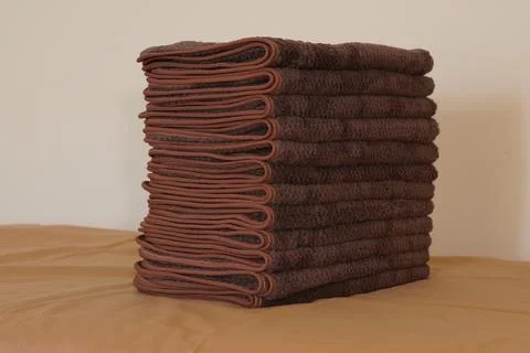 A stack of folded brown hand towels. 스톡 사진