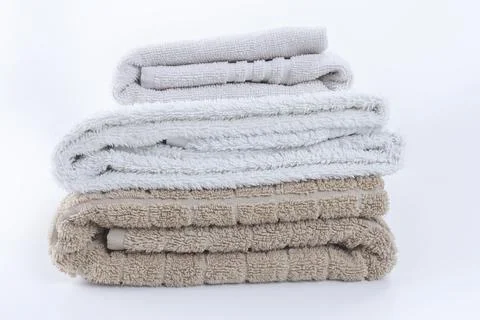 Stack of folded clean soft towels on white Stock Photos