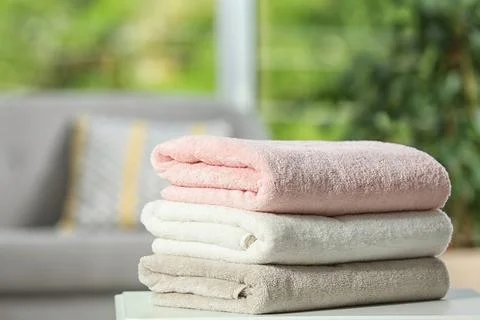 Stack of folded clean soft towels on table indoors. Space for text Foto stock