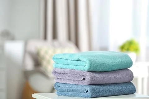 Stack of folded clean soft towels on table indoors. Space for text Stockfoto's