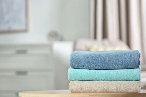 Stack of folded clean soft towels on table indoors. Space for text Foto stock