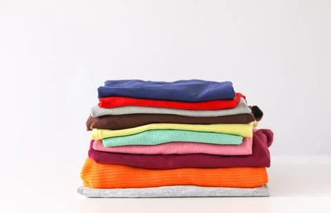 Stack of folded colorful clothes. Compact storage organizing 스톡 사진