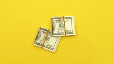 Stack of folded dollars on yellow background Stock Footage 128980210