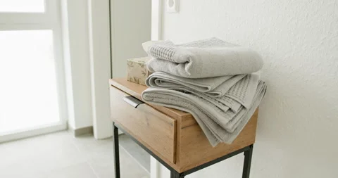 Stack of folded grey towels on wooden table in modern bathroom Stock Footage 290143902