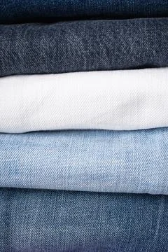 Stack of folded jeans, denim background. Close-up Stock Photos