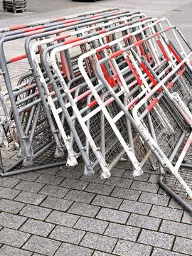 A stack of folded metal barriers with red and white stripes Stock Photos
