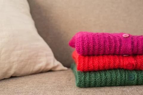 Stack of folded mohair cardigans in red, cherry and green colors. Cashmere Soft 스톡 사진