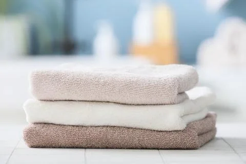 Stack of folded soft towels on bathroom surface Stock Photos