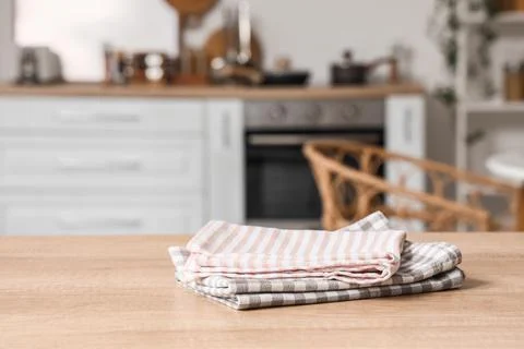 Stack of folded striped and gingham kitchen towels on wooden table in modern  Stock Photos