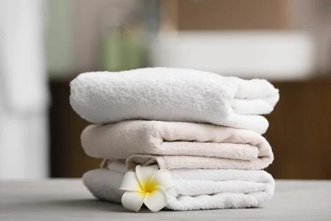 Stack of folded towels with plumeria flower Stock Photos