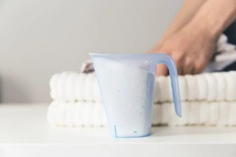 Stack of folded tpwels and washing powder detergent. Laundry and household co Stock Photos