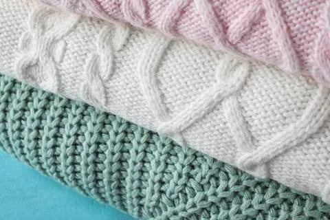 Stack of folded warm sweaters, closeup view 写真素材