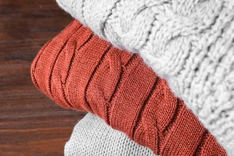 Stack of folded warm sweaters on wooden background, closeup 스톡 사진