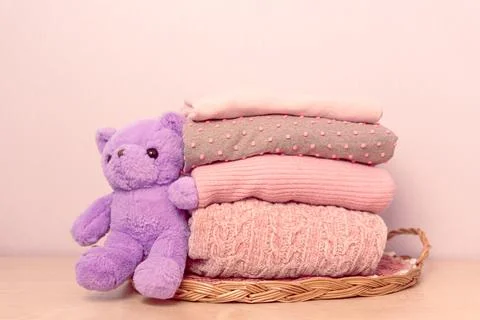 Stack of folded wool knitted sweaters or pullovers in pink pastel colors on Stock Photos