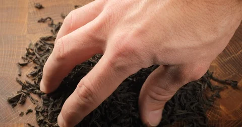 Stack of footage: Male hand picks tea leaves. Black tea. Dried tea leaves Stockbeeldmateriaal 128215990