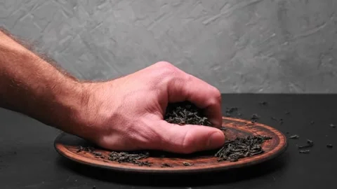 Stack of footage: Male hand picks tea leaves. Black tea. Dried tea leaves Stockbeeldmateriaal 169305852