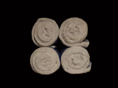 Stack of four clean bath towel rolls isolated in black background 스톡 사진