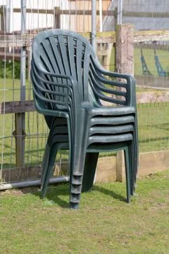 Stack of four green plastic chairs Stock Photos