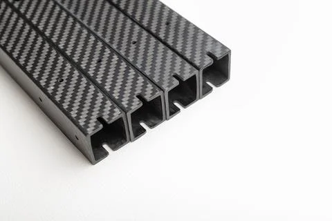 Stack of four identical square-profile carbon fiber beams is diagonally pla.. Foto stock