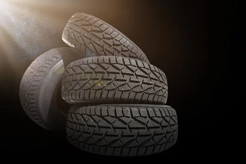 Stack of four new black tyres for winter car on black background Stock Photos