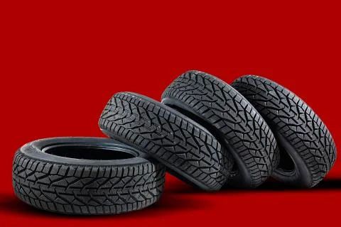 Stack of four new red tyres for winter car on blue background Stock Photos