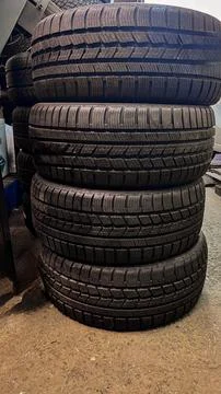 Stack of four used car tires in an auto workshop. Stock Photos