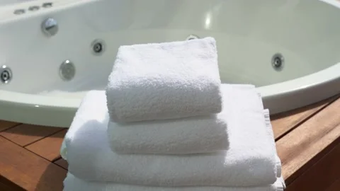 Stack of four white towels and blurry bathtub in background Video stock 139229892